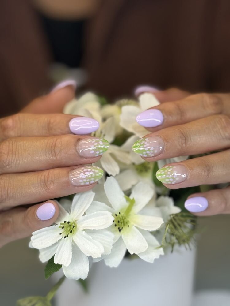 Lavender nails with delicate white flower art over a bouquet