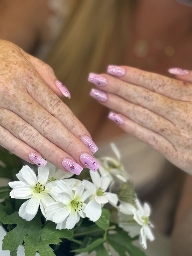 Blush pink nails with fine painted details over white flowers